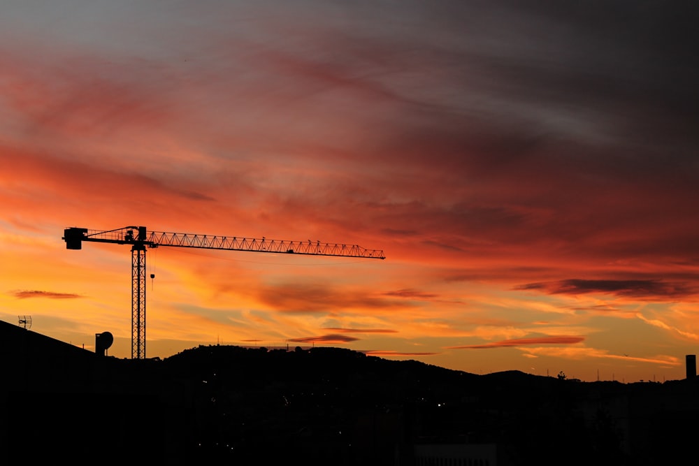 Tower crane silhouetted against a sunset sky